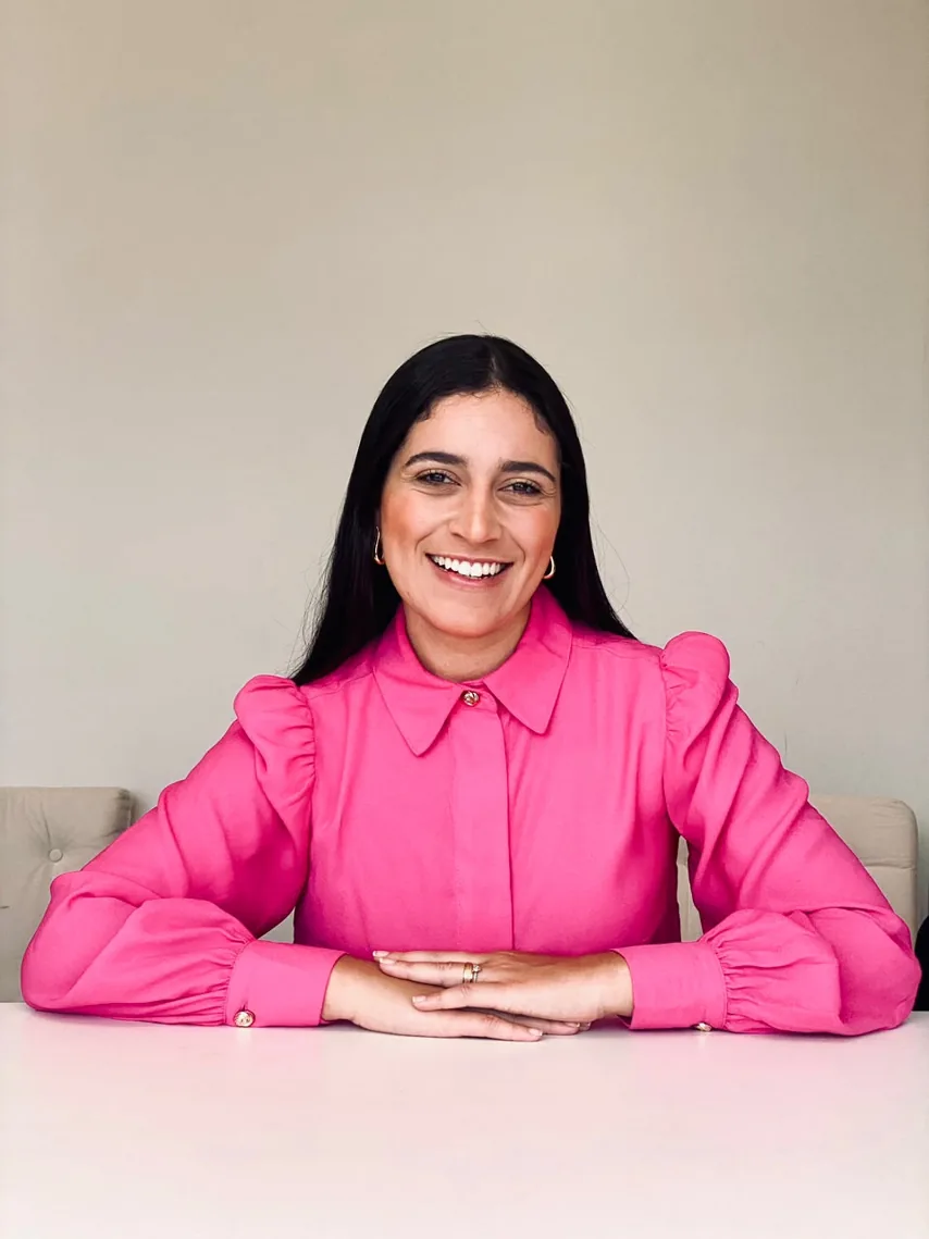 Rebeca Braga, de camisa rosa, sentada à mesa